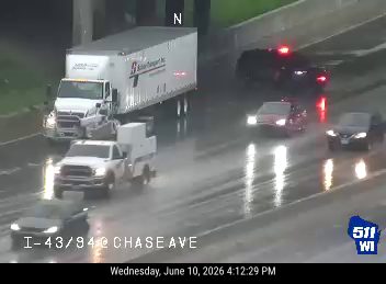 Police car with flashing lights on the highway during rainfall.