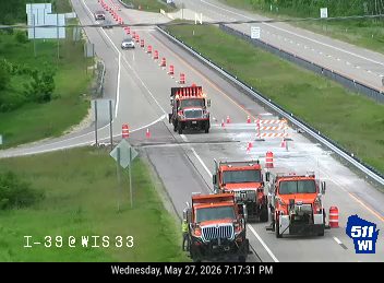 Multiple construction trucks and cones indicate road work or a responder scene.