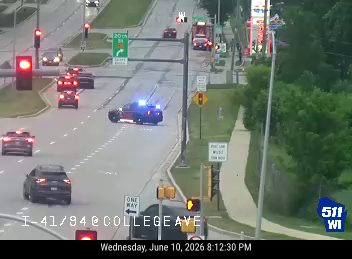 Police car with lights on at intersection, responding to an incident.