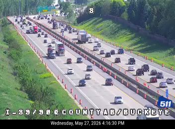 Emergency responders and cones on the highway shoulder, indicating an incident.