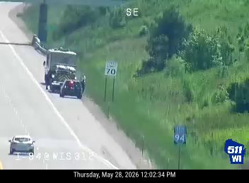 A truck and car are stopped on the roadside, possibly a responder scene.