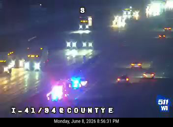 Emergency responders with flashing lights on the highway at night.