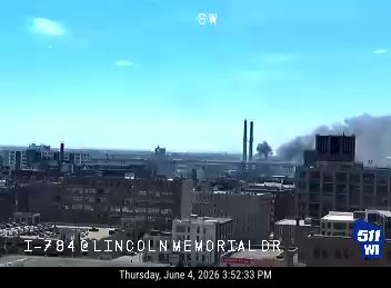 Thick smoke billowing from buildings in the distance, indicating a fire.