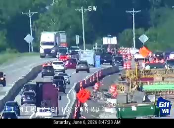 Traffic is stopped due to construction and emergency responders on the highway.
