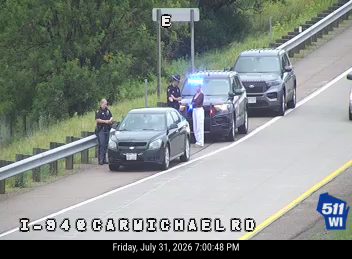 Police car with red and blue lights on the right shoulder
