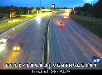 Emergency vehicle with lights on in the travel lanes of the highway.