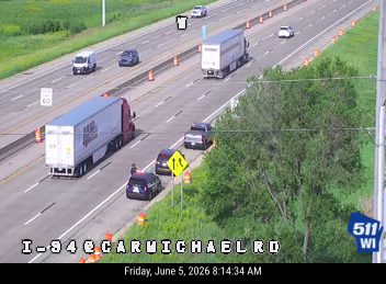 Police car and cones on the shoulder of I-94 near Carmichael Rd.