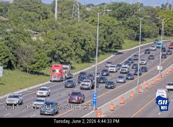 Fire truck and other vehicles stopped on the highway shoulder.
