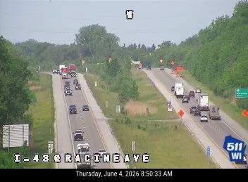 Emergency responders and vehicles are present on the right shoulder of the highway.