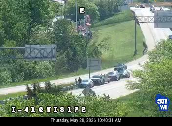 Police and other vehicles stopped on the roadway, possibly responding to an incident.