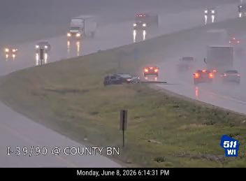 Two vehicles appear to be involved in a crash on a wet roadway.