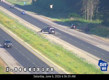 Police and possibly other responders at a roadside incident with a damaged vehicle.