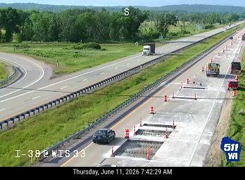 Construction vehicles and cones indicate ongoing road work, possibly a responder scene.