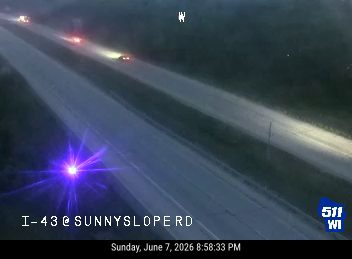 Emergency vehicle with flashing lights on the highway shoulder.