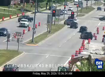 Construction vehicle and cones indicate road work or incident on the right side of the road.