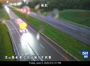 Emergency vehicle with flashing lights on the highway shoulder.