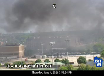 Heavy smoke billowing from a building in the distance, obscuring the sky.