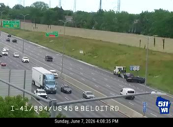 Tow truck and emergency vehicle on the shoulder with a car pulled over.