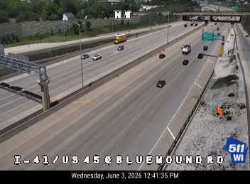Emergency responder with cones on the shoulder of the highway.