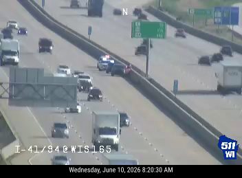 Police and emergency vehicles on the shoulder of the highway.