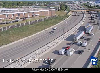 Multiple vehicles stopped in traffic, possible multi-vehicle crash on highway.