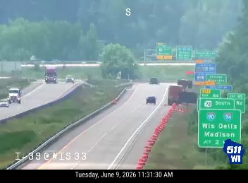 Orange traffic cones and debris are present on the roadway.