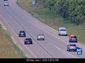 Emergency vehicle with lights on in the right lane of the highway.