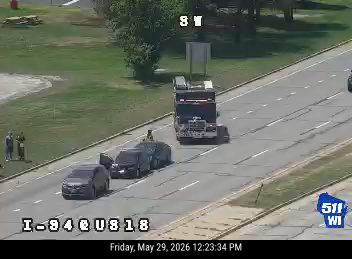 Police and tow truck on scene with personnel on the highway.