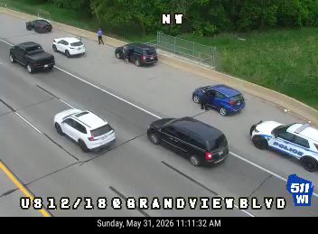 Police car and other vehicles stopped on the roadway, possibly responding to an incident.