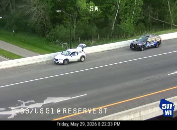 Police car and disabled vehicle on the side of the road.