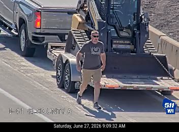 Man walking on the roadway near a trailer