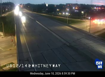 Emergency responders with flashing lights visible on the right side of the highway.