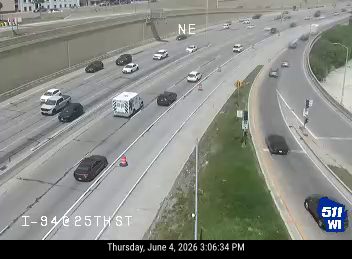 Ambulance and police vehicle on the shoulder of I-94 near 25th Street.