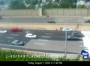 Two people and orange cones in the right lane