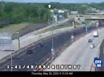 Vehicle fire on the highway with smoke and flames visible.