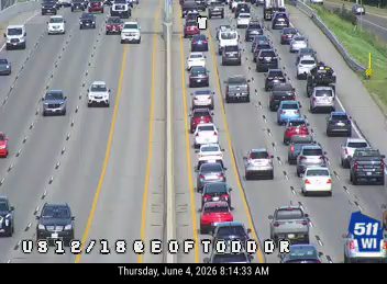 Emergency vehicle on the right shoulder, traffic is stopped.