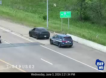 Police car stopped on the shoulder with another vehicle nearby.