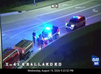 Police car with red and blue lights on the right shoulder