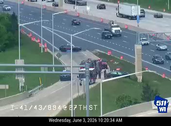 Emergency responders and vehicles are present on the highway shoulder.