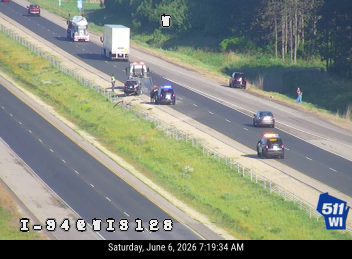 Police and tow truck on roadside assisting with a vehicle.