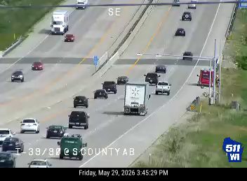 Red fire truck and emergency vehicle on the right shoulder of the highway.