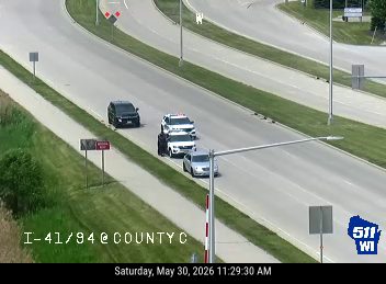 Police and other vehicles stopped on the highway, likely responding to an incident.