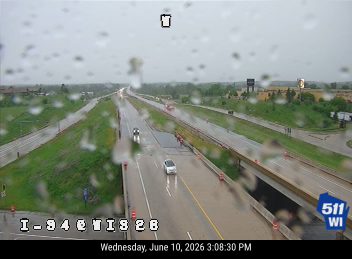 Emergency responders on the highway shoulder with cones and vehicles present personnel.