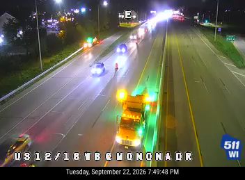 Construction vehicle with amber lights and cones in the right lane