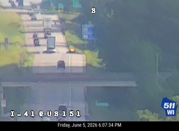 Emergency vehicle with flashing lights on the highway, likely responding to an incident.