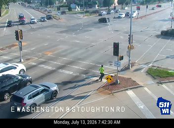 Person in high-visibility vest crossing roadway