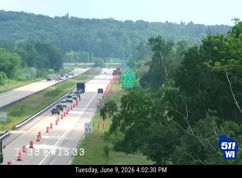 Orange cones and debris are present on the roadway, indicating a possible incident.