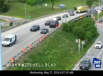 Tow truck and police vehicle on the shoulder of I-94 at Mitchell Blvd.