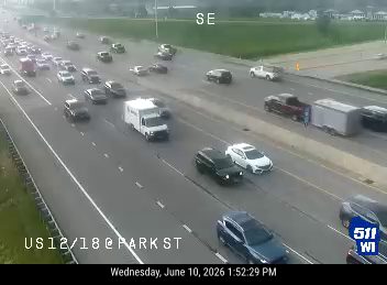 Emergency vehicles and a tow truck are stopped on the highway, possibly attending to an incident.
