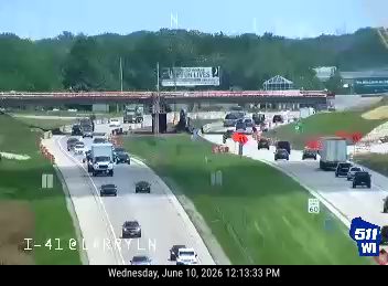 Emergency responders and vehicles are present on the highway shoulder.